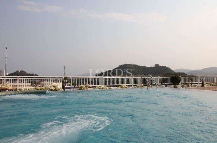 Rooftop swimming pool with clear blue water and mountain views in the background