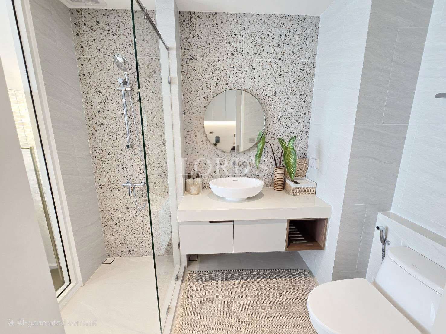 Modern minimalist bathroom with terrazzo accent wall, glass shower enclosure, floating vanity, round mirror, and vessel sink.