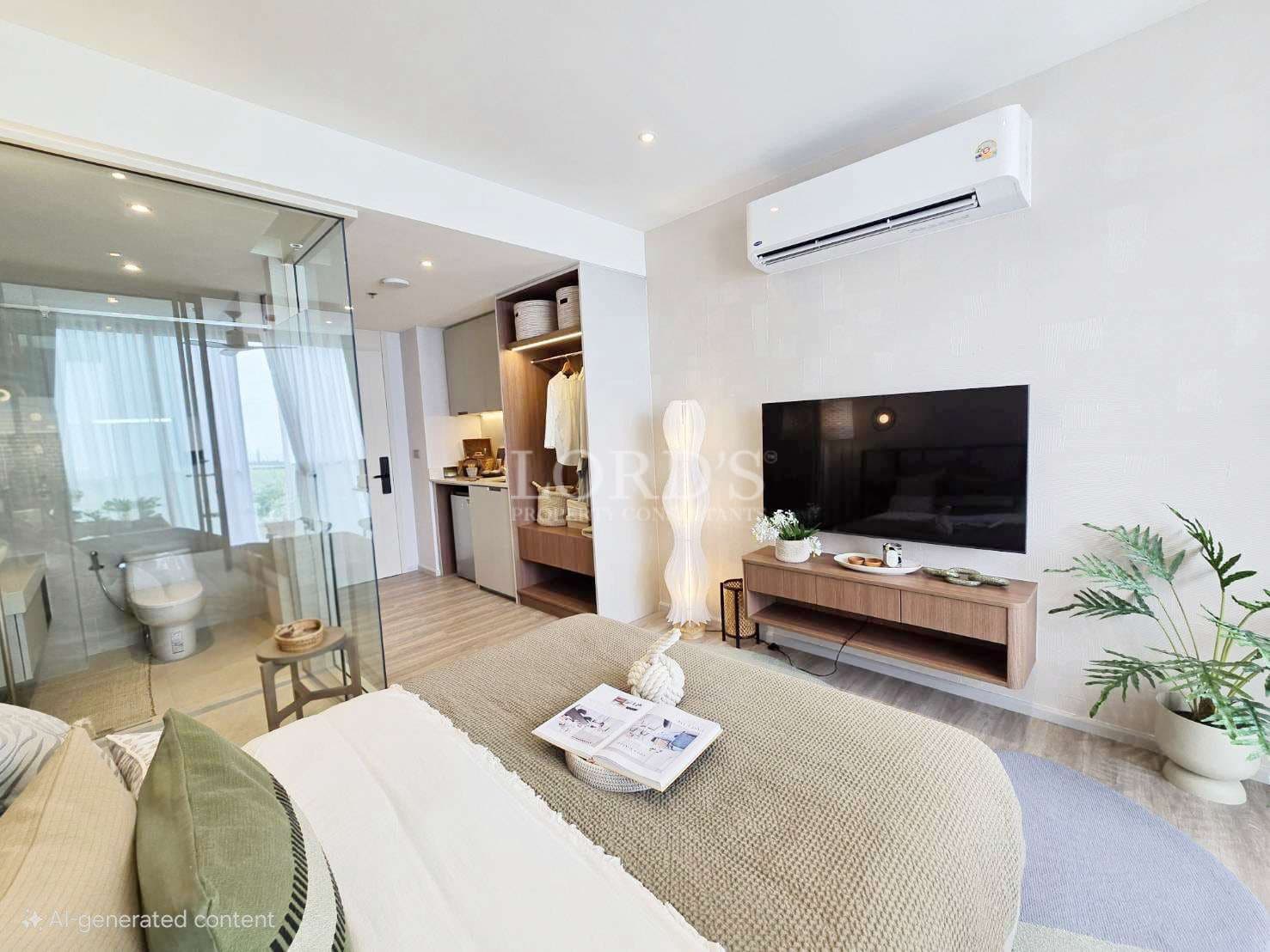 Modern bedroom interior with wall-mounted TV, glass-enclosed bathroom, air conditioner, wooden flooring, neutral decor, and minimalist furniture.