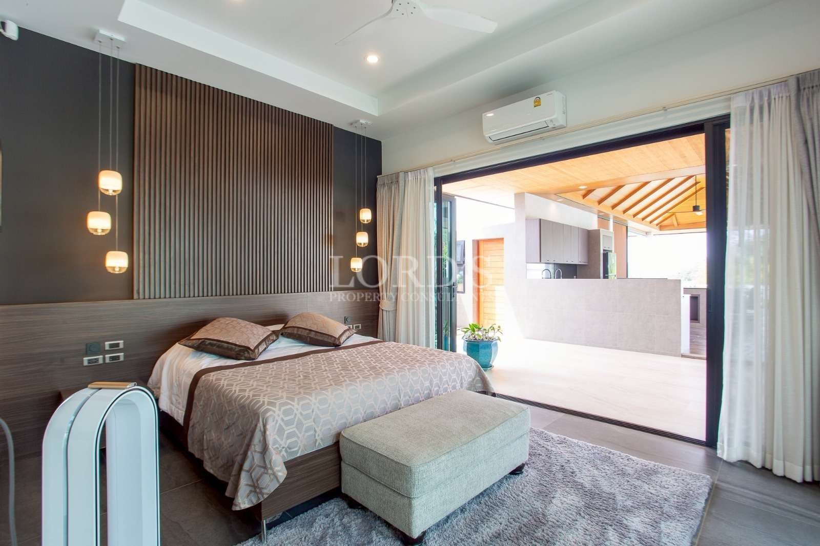 Modern bedroom with sliding glass doors opening to a covered outdoor terrace.