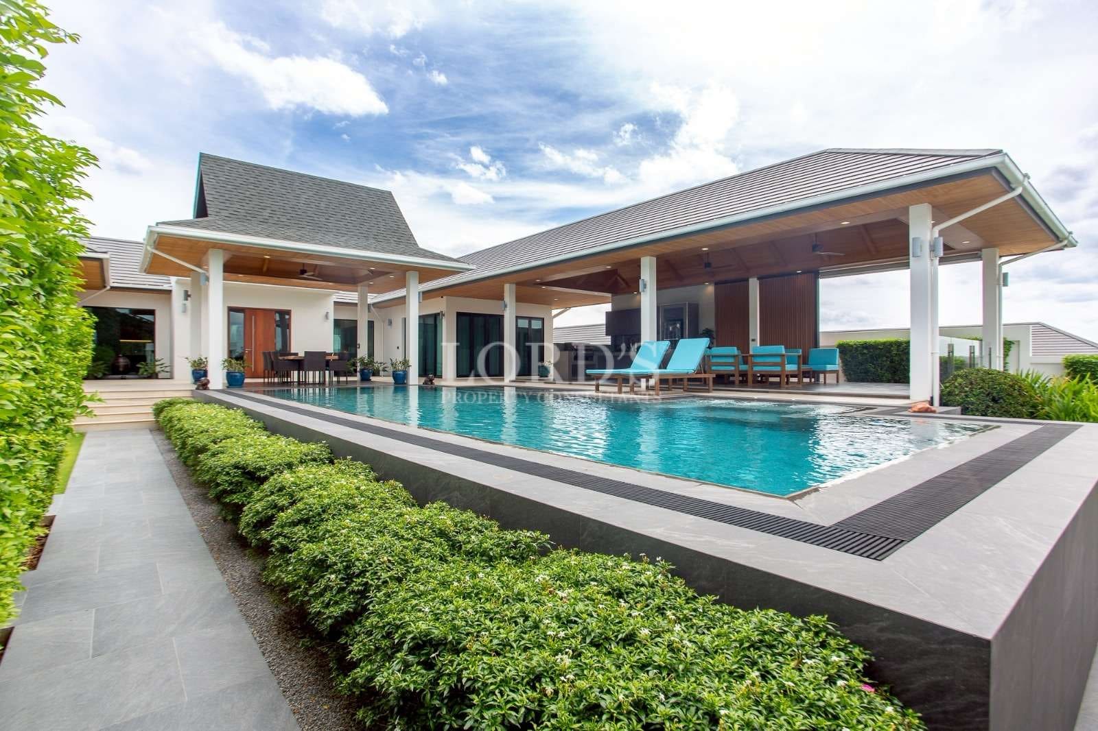 Luxury modern villa with private swimming pool, covered terrace, and outdoor lounge seating.