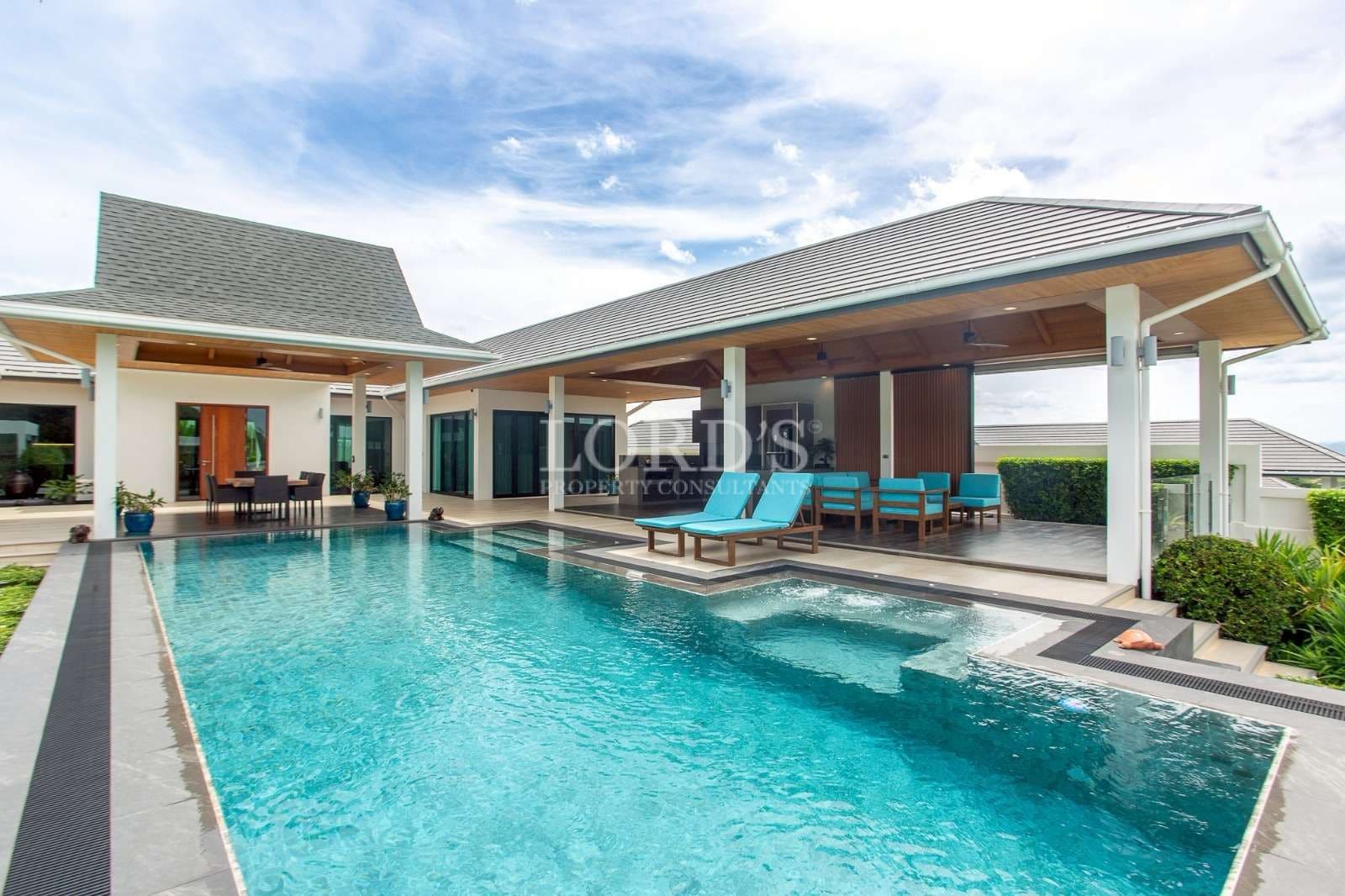 Modern luxury villa with private swimming pool, covered outdoor lounge, and contemporary architecture.