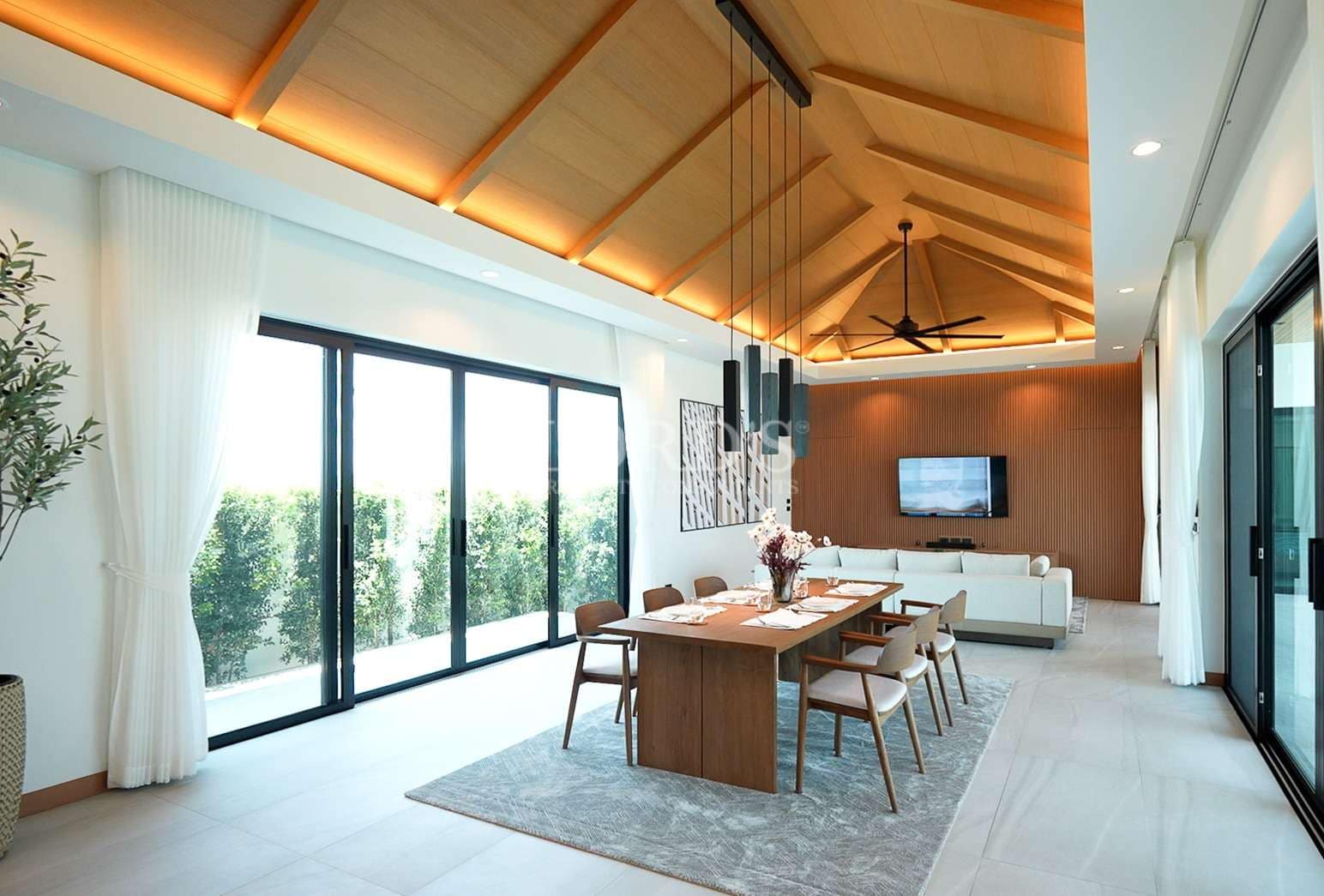 Luxury open-plan living and dining area with wooden ceiling, large glass doors, pendant lighting, and modern furniture.