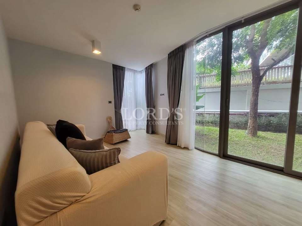 Modern living room with floor-to-ceiling glass doors and garden view.