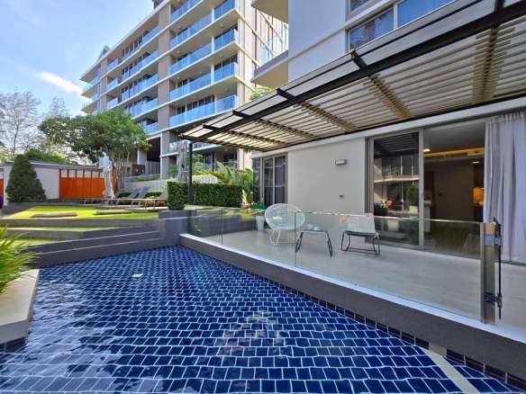 Modern apartment terrace with private swimming pool, pergola seating area, and landscaped garden.