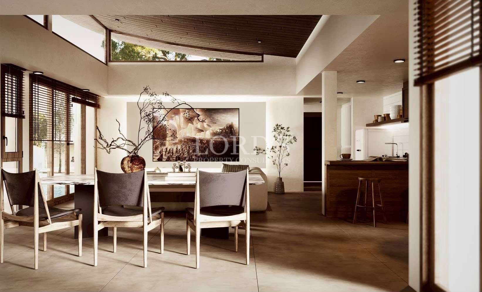 Modern open-plan dining and kitchen area with wooden ceiling, minimalist furniture, and natural light.