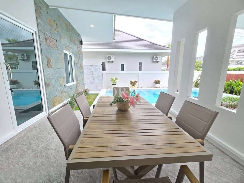 Modern outdoor dining area by pool