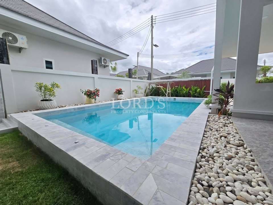 Modern pool surrounded by greenery.