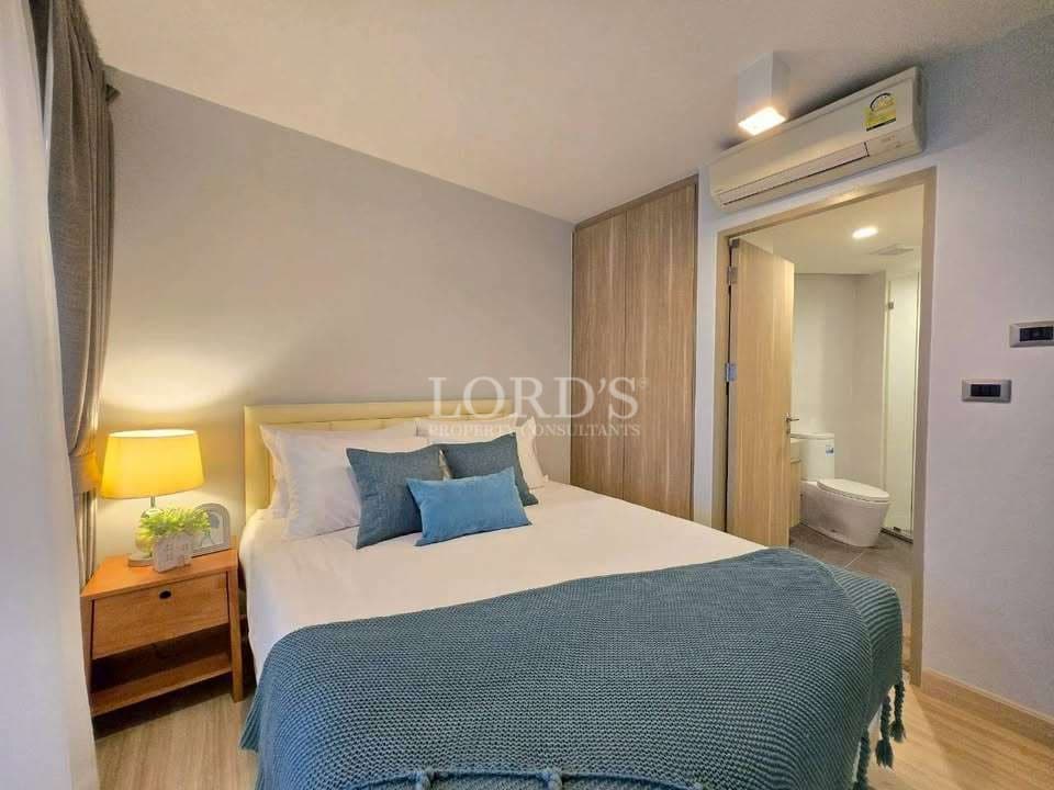 Modern bedroom with queen bed, wooden wardrobe, air conditioning, and ensuite bathroom.
