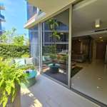 Private patio with outdoor seating and sliding glass doors opening to a modern living room.