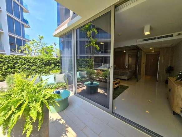 Private patio with outdoor seating and sliding glass doors opening to a modern living room.