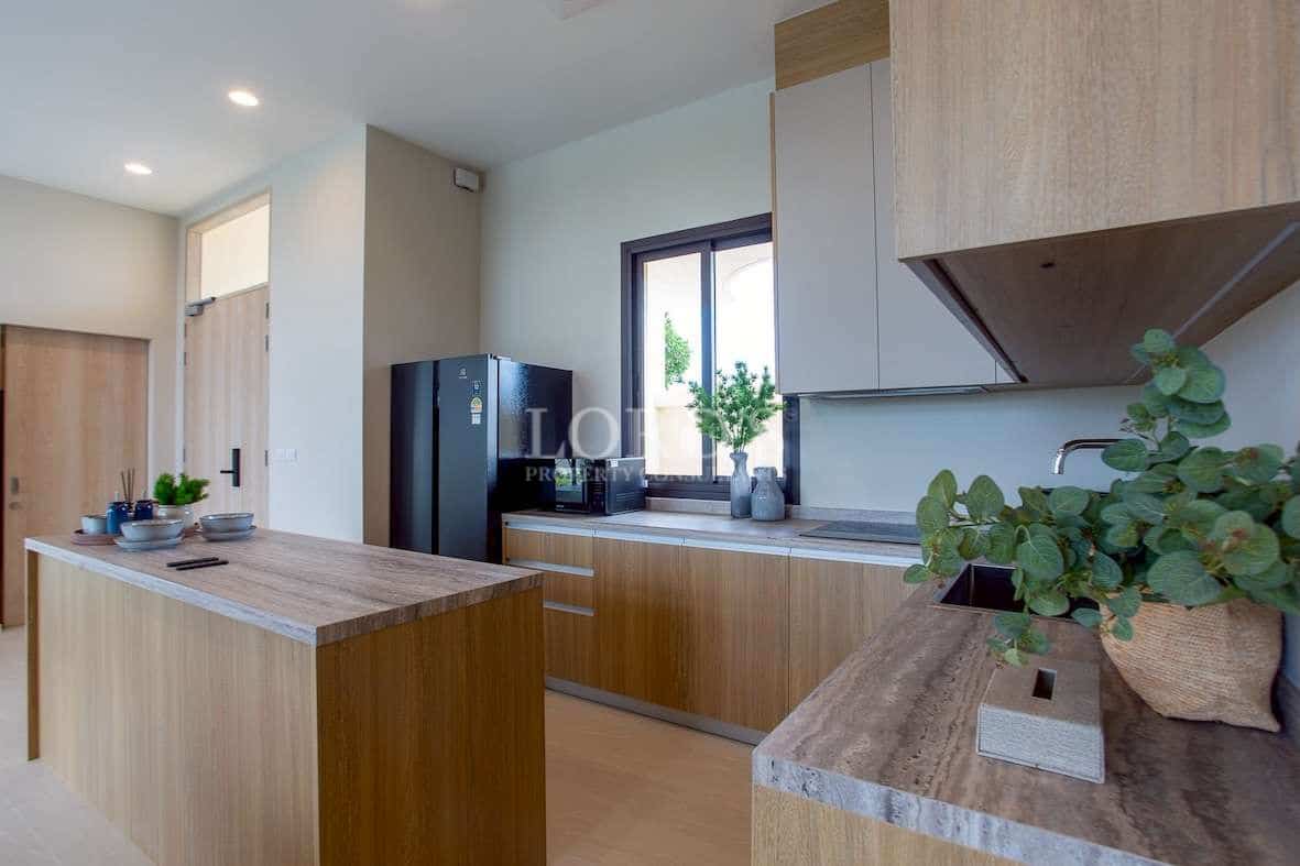 Modern kitchen with wooden cabinetry, island counter, natural light, and minimalist design.