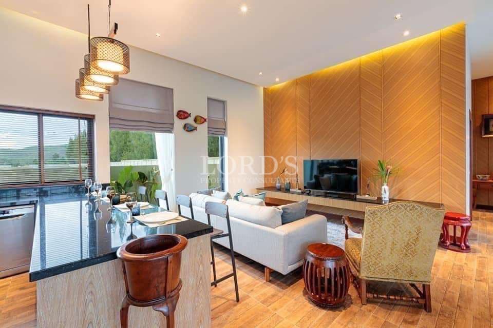 Modern open-plan living and dining area with wooden accent wall, kitchen island, and stylish lighting.