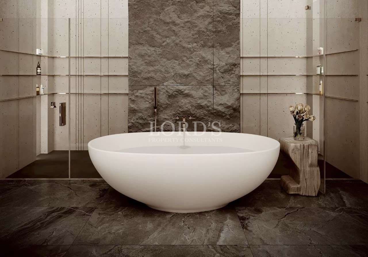 Luxury spa bathroom with freestanding oval bathtub, stone walls, and minimalist design.