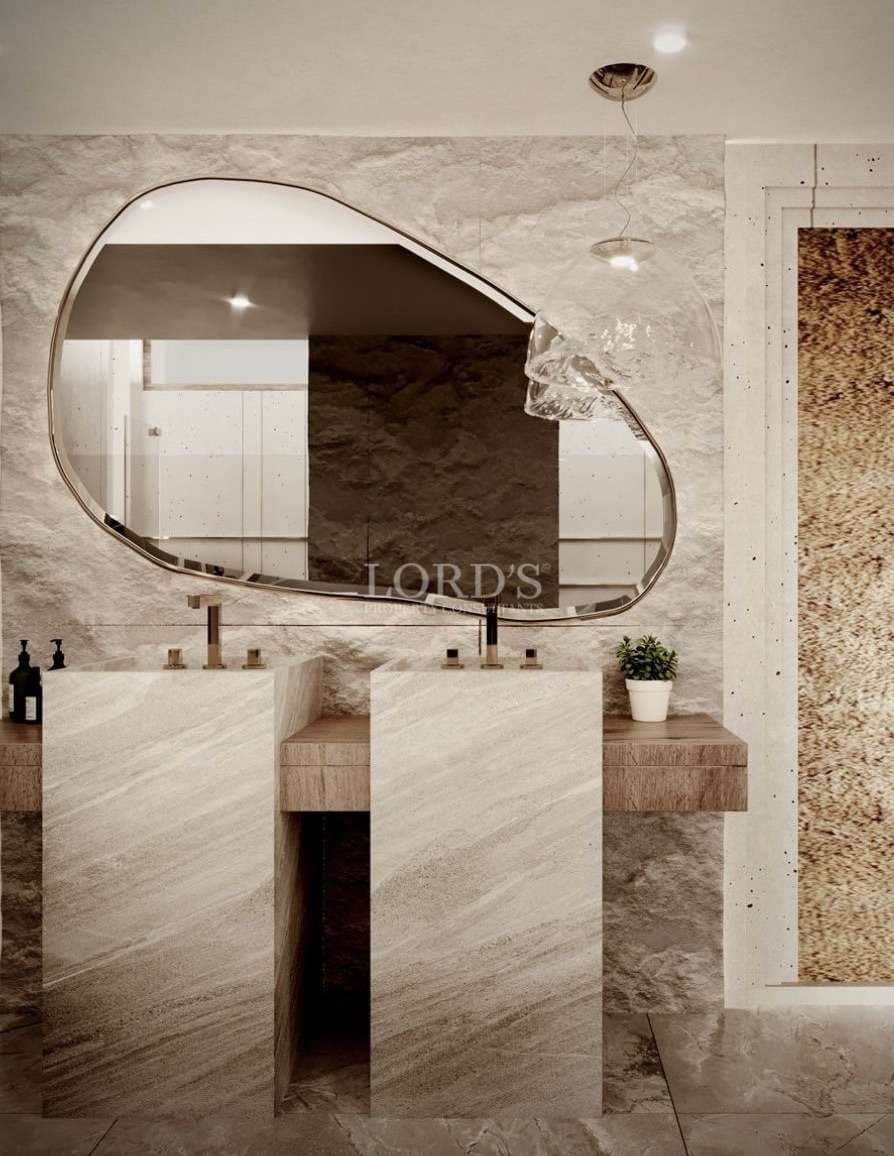 Luxury designer bathroom with sculptural mirror, stone vanity, and minimalist modern fixtures.