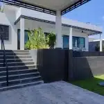 Modern luxury house exterior with elevated terrace, outdoor steps, landscaped garden, and contemporary design.