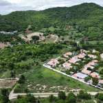 Aerial view of green landscape and houses.