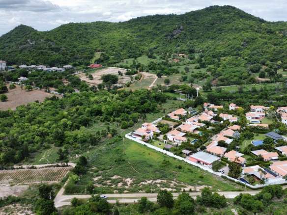 Aerial view of green landscape and houses.