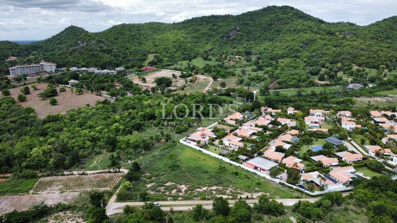 Aerial view of green landscape and houses.