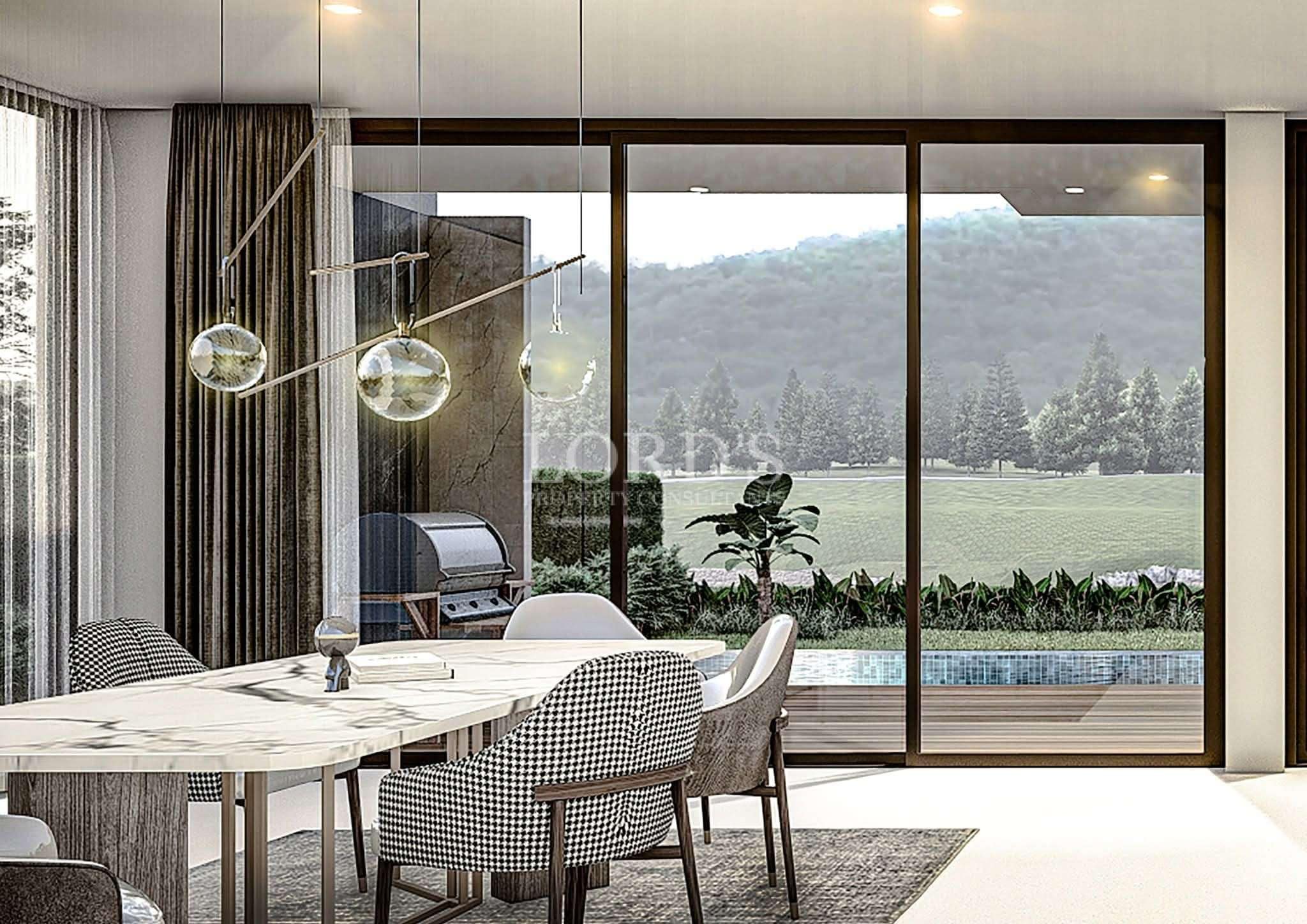 Elegant dining area with marble dining table, modern pendant lights, floor-to-ceiling glass doors, and scenic garden views.