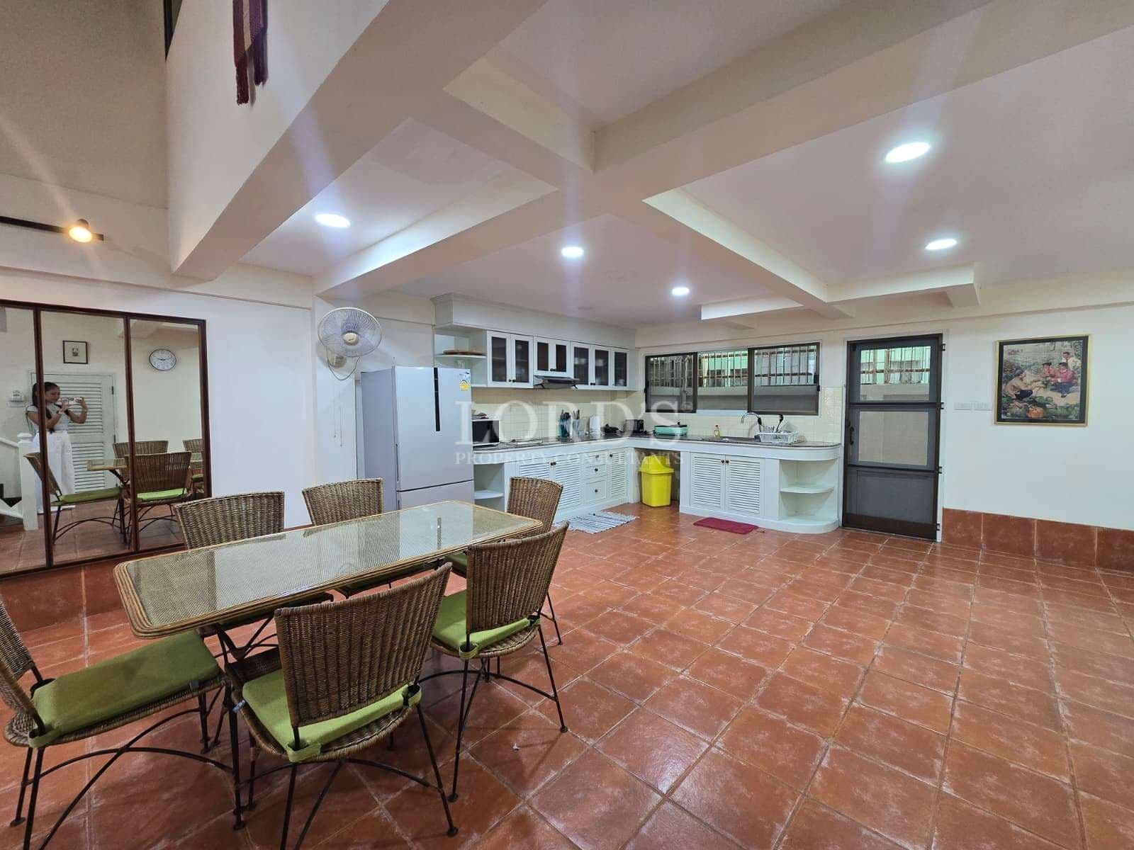 Spacious open-plan kitchen and dining area with tiled flooring and built-in cabinetry.
