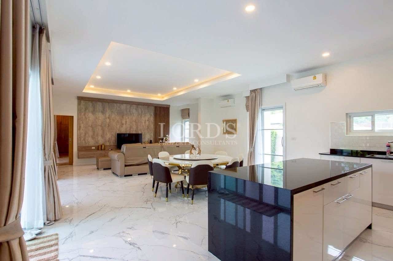 Modern open-plan living and dining area with kitchen island and recessed lighting.