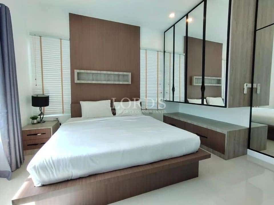 Modern bedroom with wooden accent wall, platform bed, and built-in dressing table with mirror.