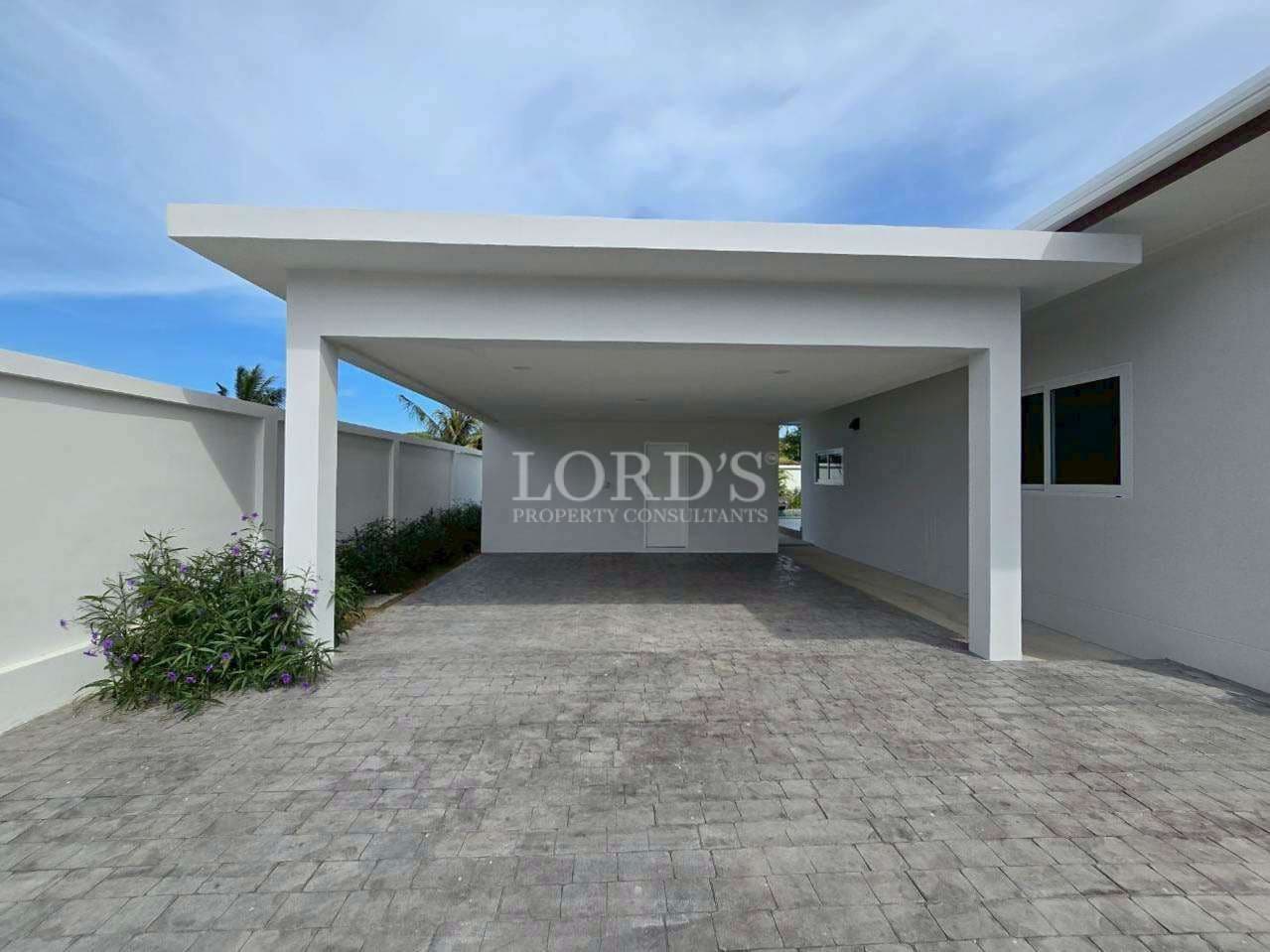 Modern carport with paved driveway.