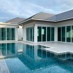 Modern luxury villa with a private swimming pool, large glass doors, and a spacious poolside terrace.