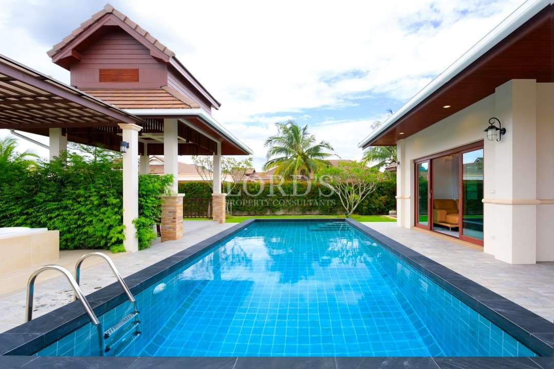 Private swimming pool in a modern luxury villa with covered terrace, tropical garden, and direct access from living area