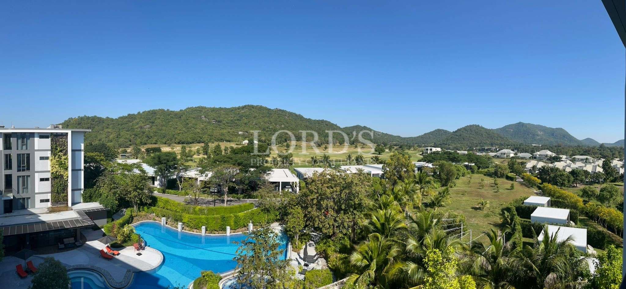 WhatsApp Image 2025-11-30 at 16.12.50 Aerial view of luxury residential area with swimming pool, palm trees, and mountain backdrop