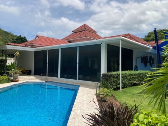 Modern single-storey villa with private swimming pool, covered terrace, red-tiled roof, and landscaped garden.