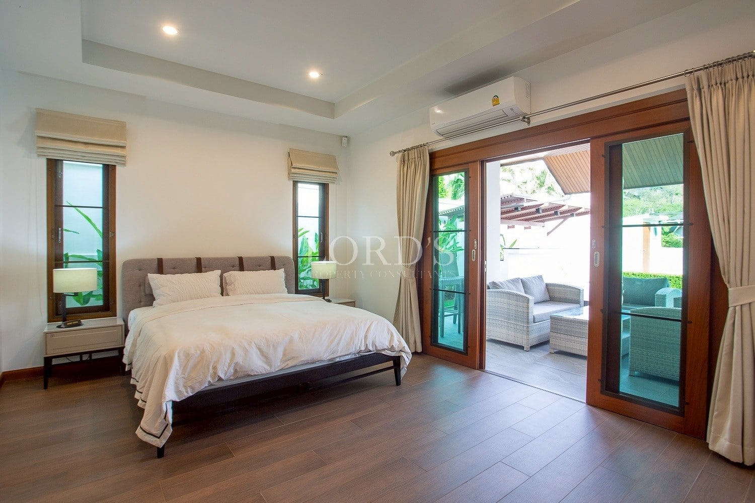 Spacious modern bedroom with king bed and sliding glass doors to private patio