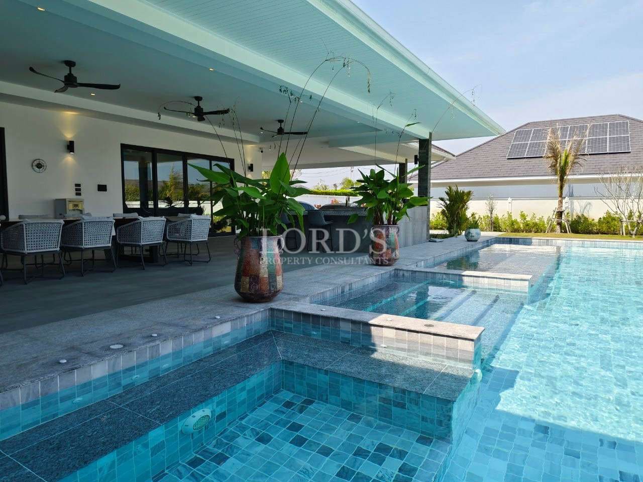Modern poolside patio with greenery.
