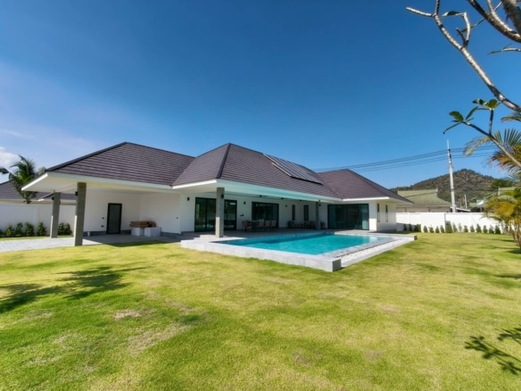 Modern single-story pool villa with private swimming pool, landscaped lawn, and contemporary exterior design.
