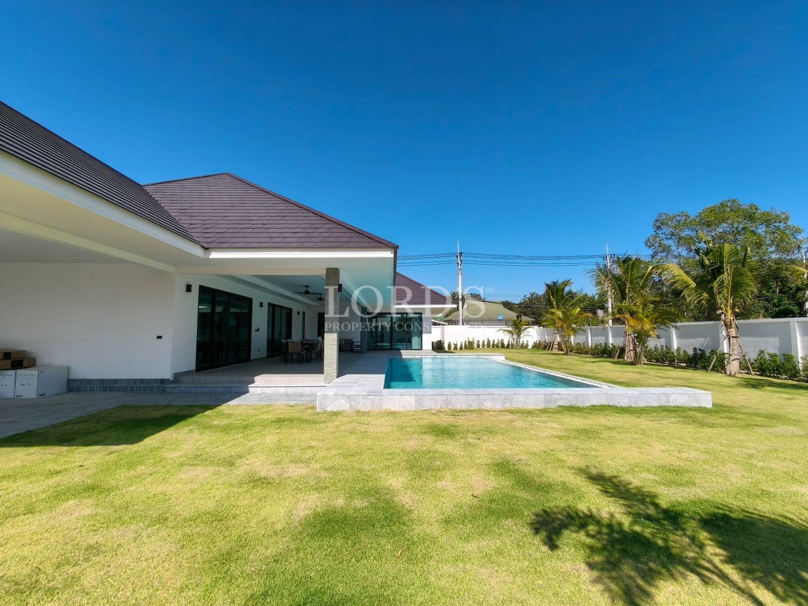 Modern pool villa with private swimming pool, covered terrace, and landscaped lawn.