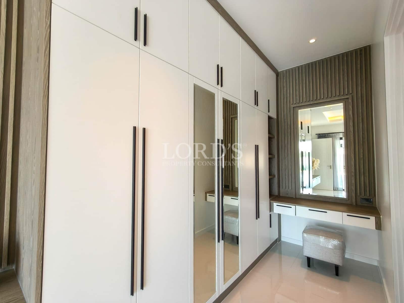 Built-in wardrobe with mirrored doors, custom cabinetry, and integrated dressing table.