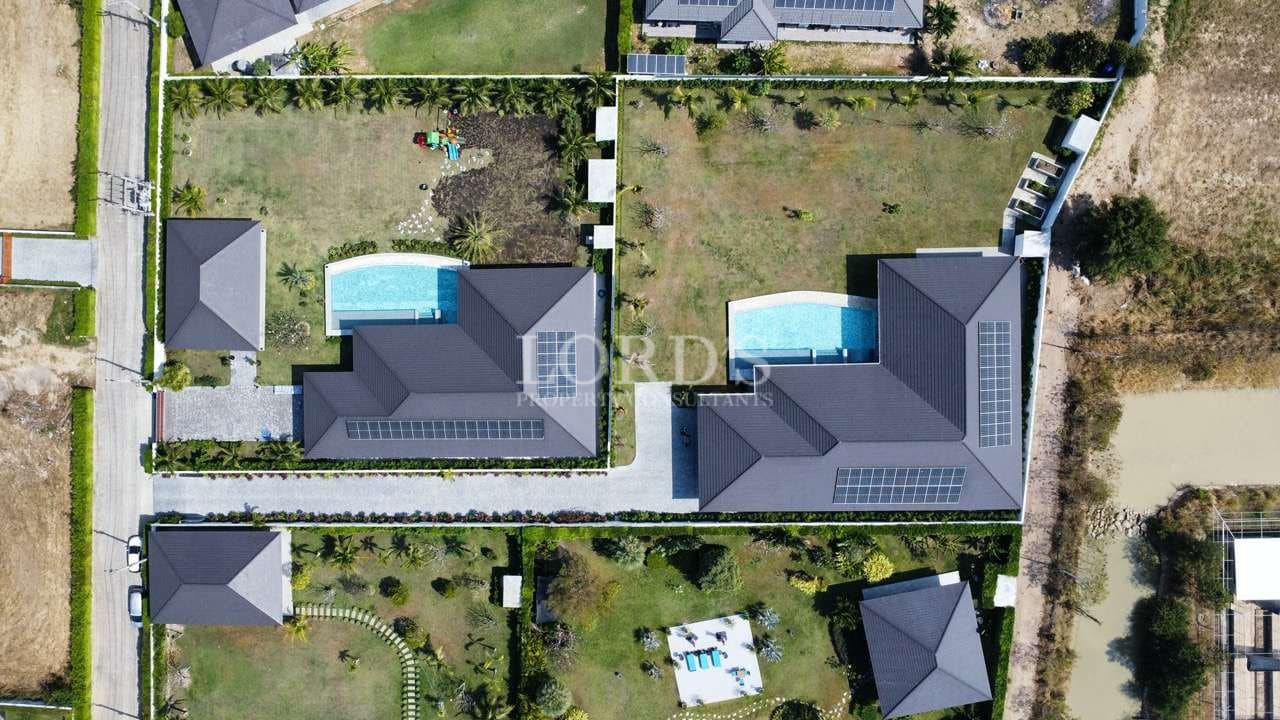 Aerial view of luxury homes and pools.