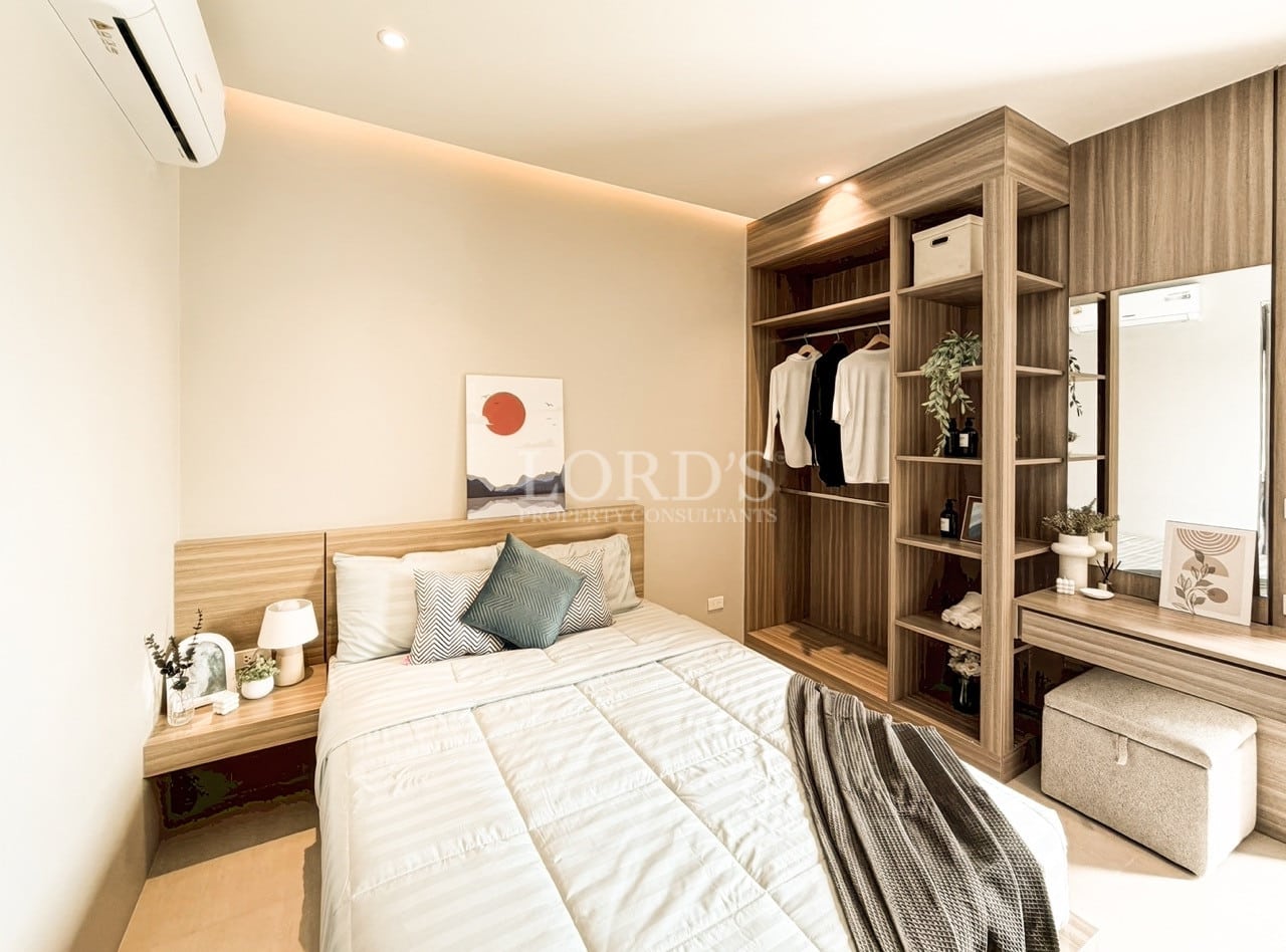 Elegant bedroom with built-in wooden wardrobe, vanity area, and soft ambient lighting.