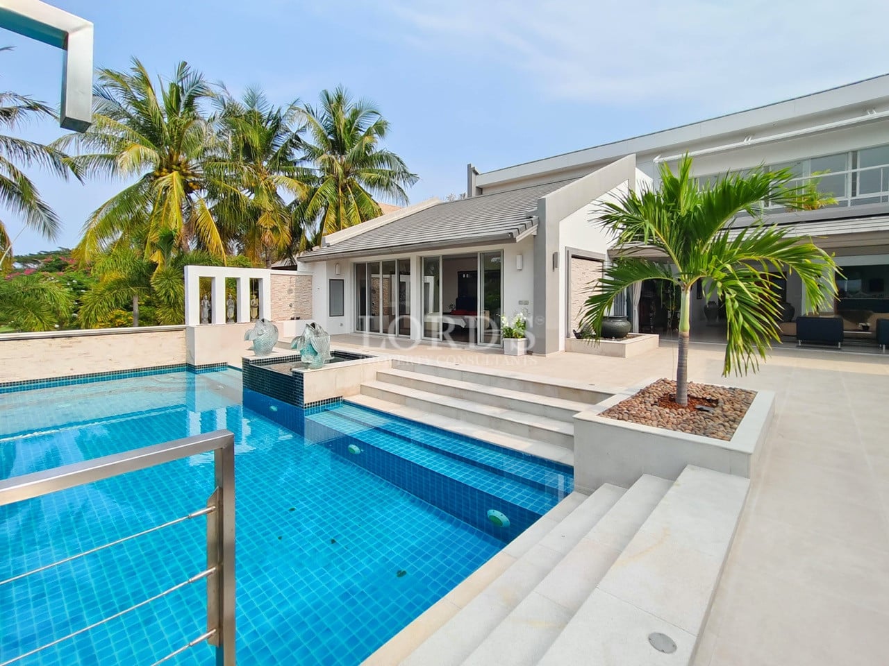 Modern luxury villa with private swimming pool, palm trees, and outdoor terrace