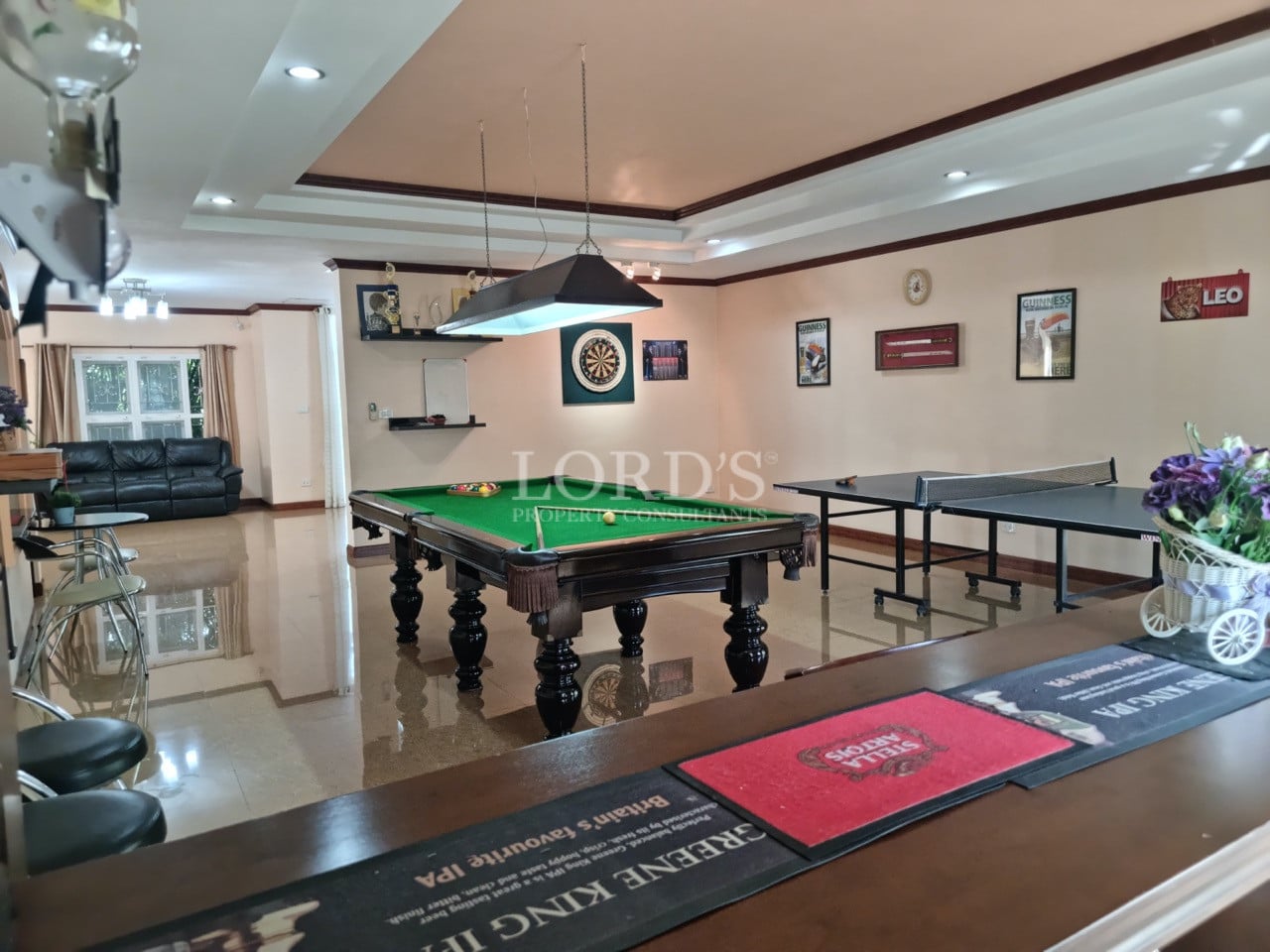 Luxury entertainment room with billiards table, ping pong table, and modern lighting.